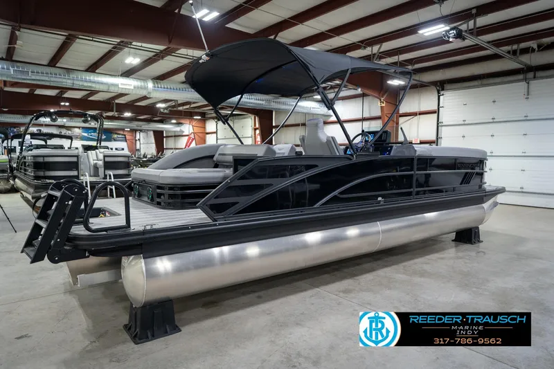 Slide: The Image of 2026 Bennington 26 MSB pontoon boat in showroom with canopy and sleek design. - 7