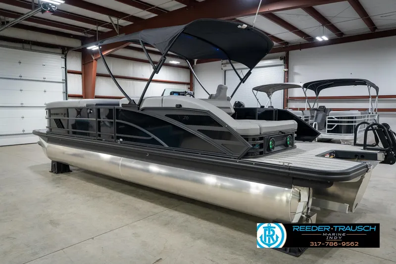 Slide: The Image of 2026 Bennington 26 MSB pontoon boat in showroom with canopy and sleek design. - 9