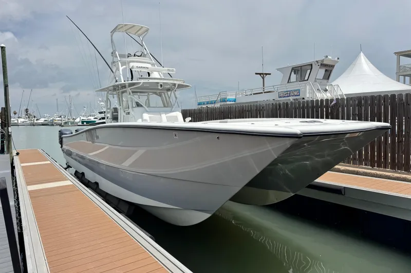 Slide: The Image of 2018 Freeman 42 boat docked at marina, sleek design, overcast sky. - 1