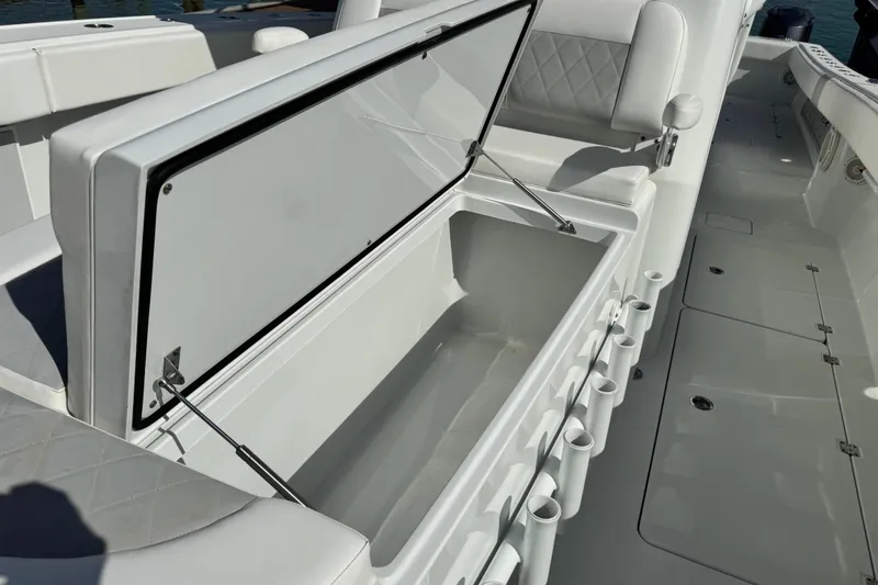 Slide: The Image of Open storage compartment on 2018 Freeman 42 LR boat with rod holders. - 12