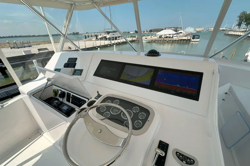 Slide: The Image of 2003 Viking 48 Convertible yacht cruising on open sea under clear sky. - 57