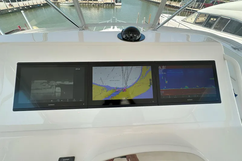 Slide: The Image of 2003 Viking 48 Convertible yacht cruising on open water under a clear sky. - 58