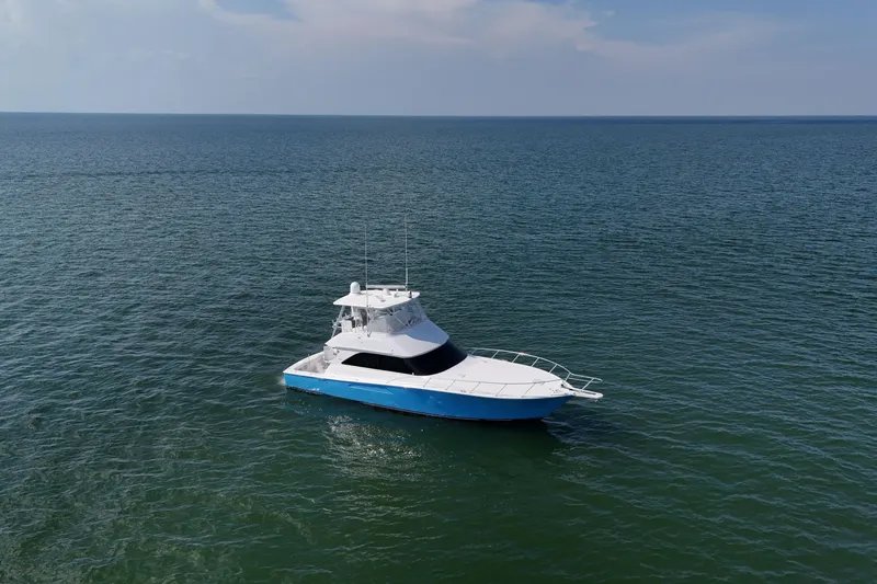 Slide: The Image of 2003 Viking 48 Convertible yacht docked in marina, featuring sleek blue hull design. - 7