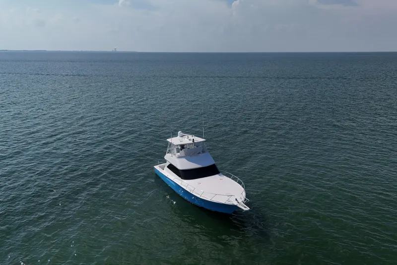 Slide: The Image of 2003 Viking 48 Convertible yacht docked, featuring a sleek blue and white design. - 8