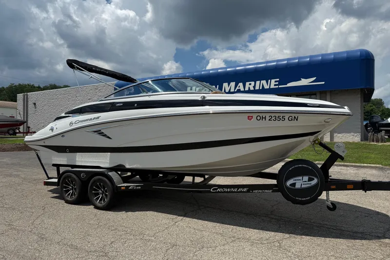 The Image of 2024 Crownline Eclipse E235 boat on trailer, parked outside marine dealership. - 0