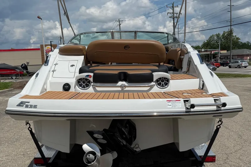 Slide: The Image of 2024 Crownline Eclipse E235 boat with teak deck and seating, parked outdoors. - 11