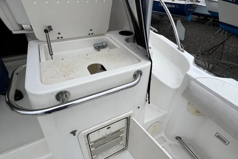 Slide: The Image of 2005 Boston Whaler 305 Conquest boat interior with open storage compartment. - 10