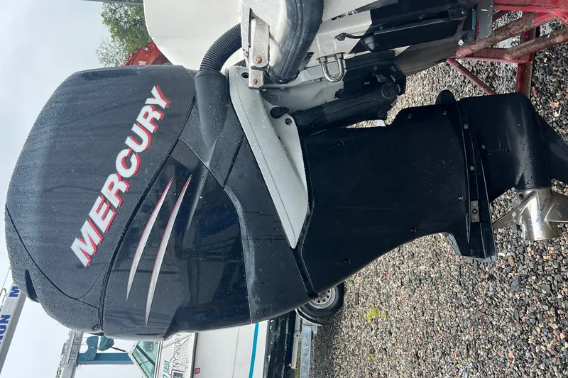 Slide: The Image of Mercury outboard motor on a 2005 Boston Whaler 305 Conquest, parked on gravel. - 3