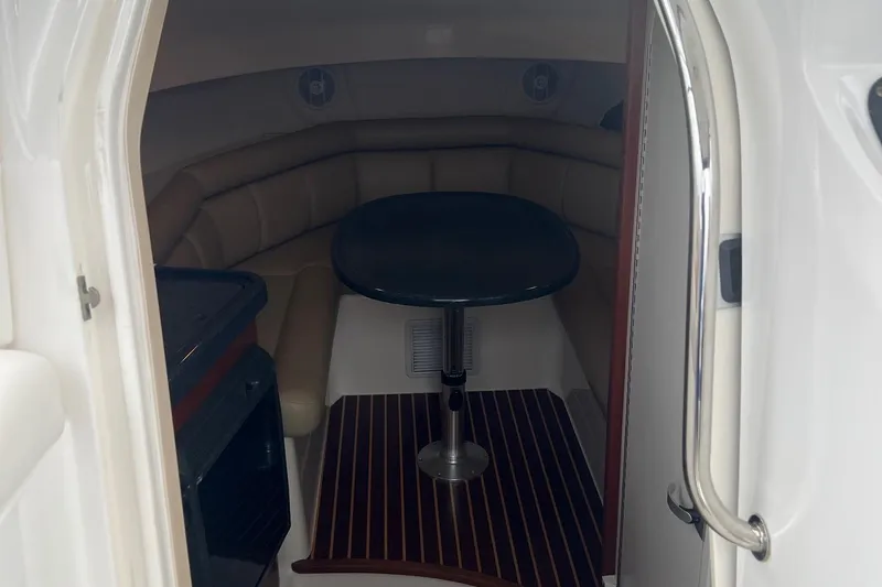 Slide: The Image of 2005 Boston Whaler 305 Conquest cabin interior with seating and table. - 36