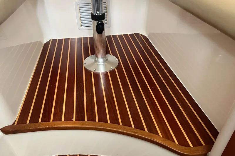 Slide: The Image of Teak flooring in 2005 Boston Whaler 305 Conquest cabin, featuring sleek wood finish. - 38