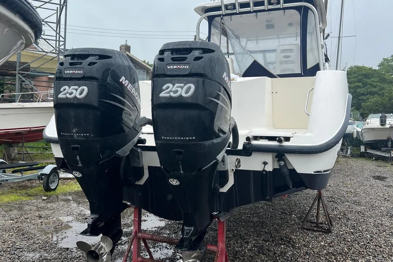 Slide: The Image of 2005 Boston Whaler 305 Conquest with twin Mercury Verado 250 engines, docked on gravel. - 4