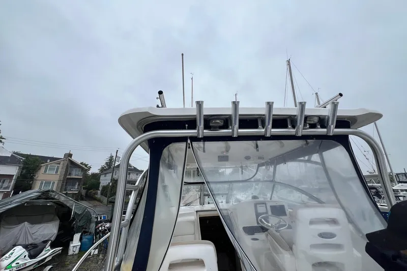 Slide: The Image of 2005 Boston Whaler 305 Conquest boat with rod holders and clear cockpit cover. - 6