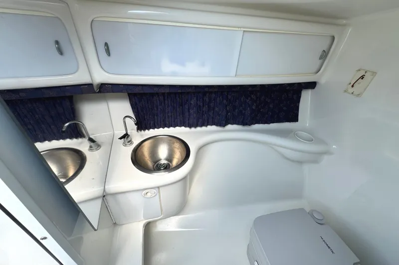 Slide: The Image of Interior view of a 2001 Formula 280 Bowrider boat, featuring white seating and blue accents. - 25