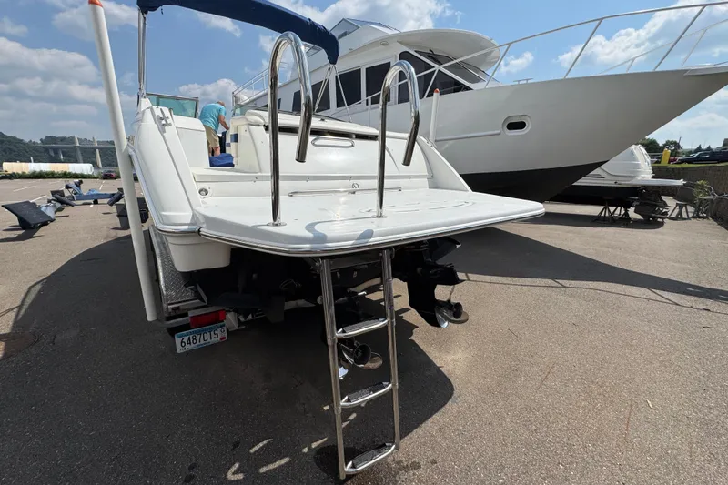 Slide: The Image of 2001 Formula 280 Bowrider boat on trailer, parked near a marina with other boats. - 4