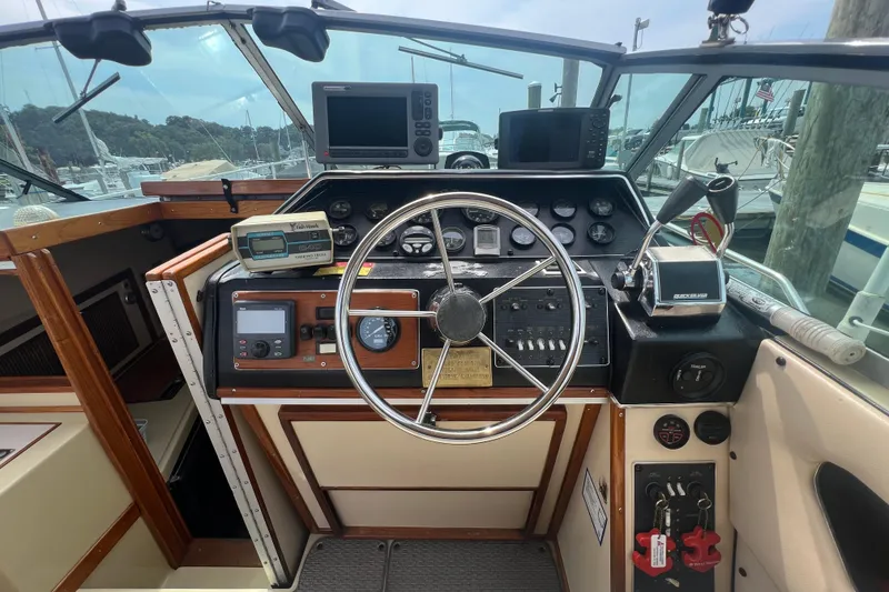 Slide: The Image of 1986 Sea Ray 270 Amberjack helm with steering wheel, gauges, and navigation equipment. - 17