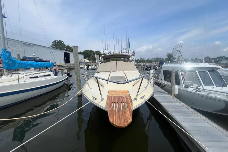 Slide: The Image of 1986 Sea Ray 270 Amberjack docked at marina, surrounded by other boats. - 2