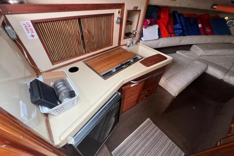 Slide: The Image of 1986 Sea Ray 270 Amberjack cabin interior with kitchenette and seating area. - 27