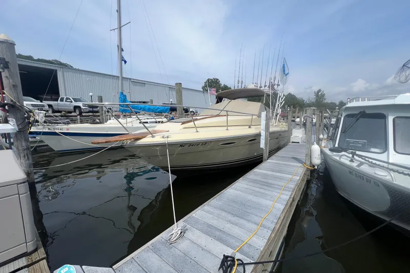 Slide: The Image of 1986 Sea Ray 270 Amberjack docked at marina, surrounded by other boats. - 3