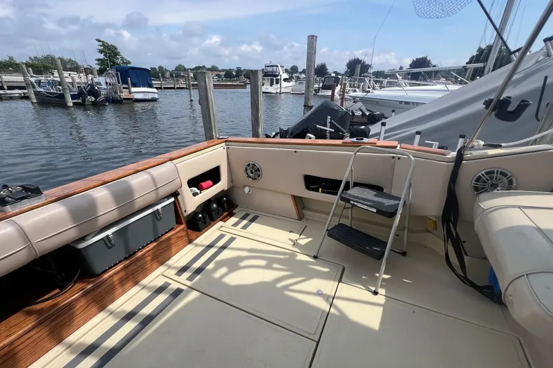 Slide: The Image of 1986 Sea Ray 270 Amberjack boat interior at marina, featuring seating and storage. - 4