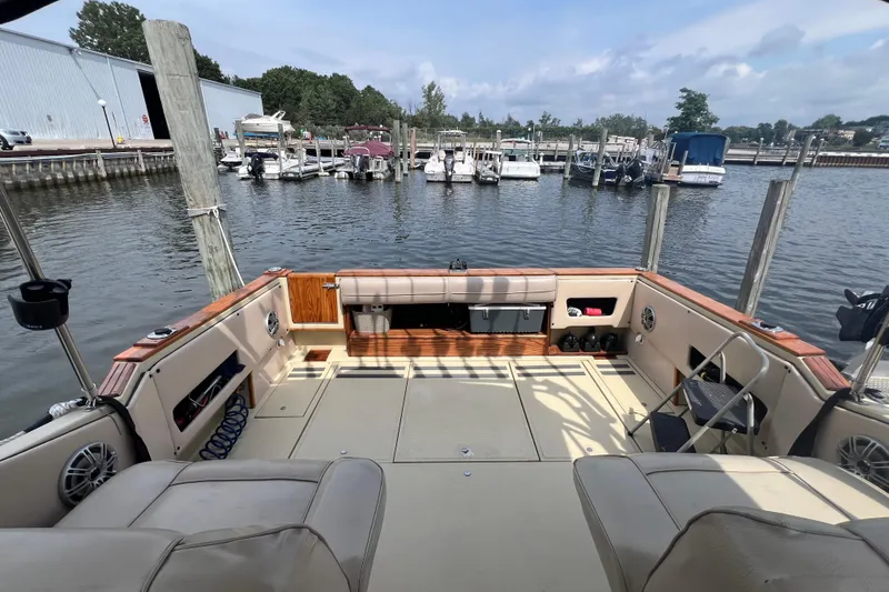 Slide: The Image of 1986 Sea Ray 270 Amberjack boat interior at marina, showcasing spacious deck and seating. - 7