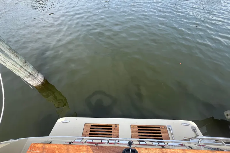 Slide: The Image of 1986 Sea Ray 270 Amberjack boat stern near dock in calm water. - 9