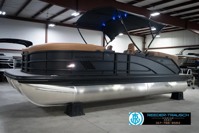 Slide: The Image of 2026 Bennington 22 MFB pontoon boat in showroom with canopy and seating. - 3