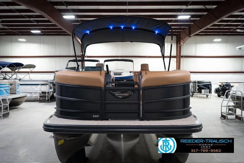 Slide: The Image of 2026 Bennington 22 MFB pontoon boat in showroom with canopy and tan seating. - 4
