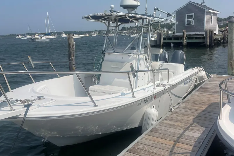 The Image of Edgewater 247CC 2002 boat docked at marina, surrounded by calm water and other vessels. - 0