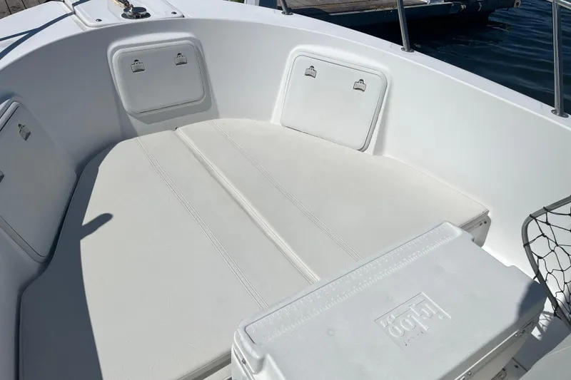 Slide: The Image of 2002 Edgewater 247CC boat interior with cushioned seating and storage compartments. - 2