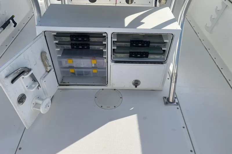 Slide: The Image of Open storage compartment on 2002 Edgewater 247CC boat with organized tackle boxes. - 5