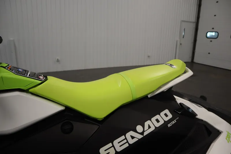 Slide: The Image of 2023 Sea-Doo SPARK 3 IBR CONV SS with vibrant green seat in a showroom. - 17