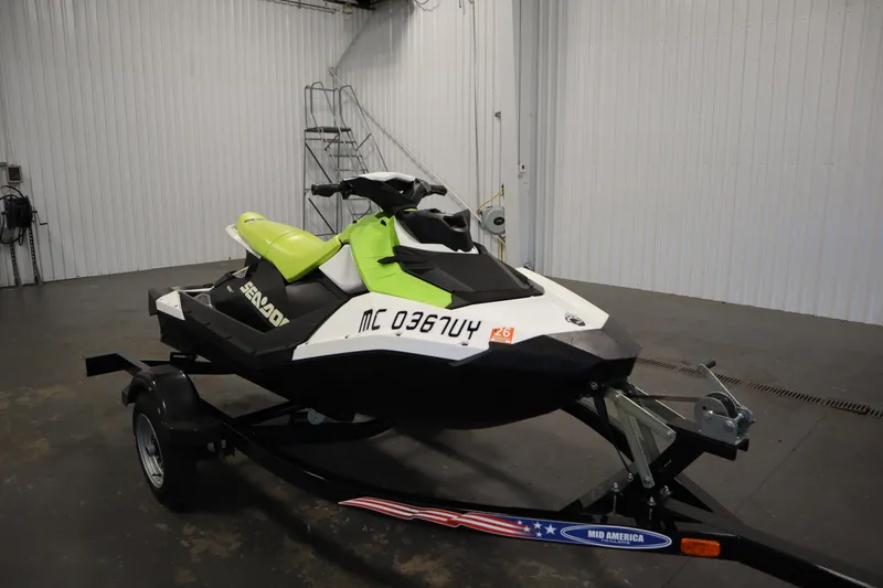Slide: The Image of 2023 Sea-Doo Spark 3up jet ski in a spacious indoor garage. - 3