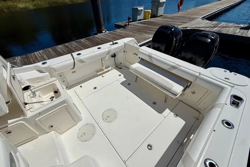 Slide: The Image of 2007 Boston Whaler 285 Conquest boat deck with seating and twin engines at dock. - 12