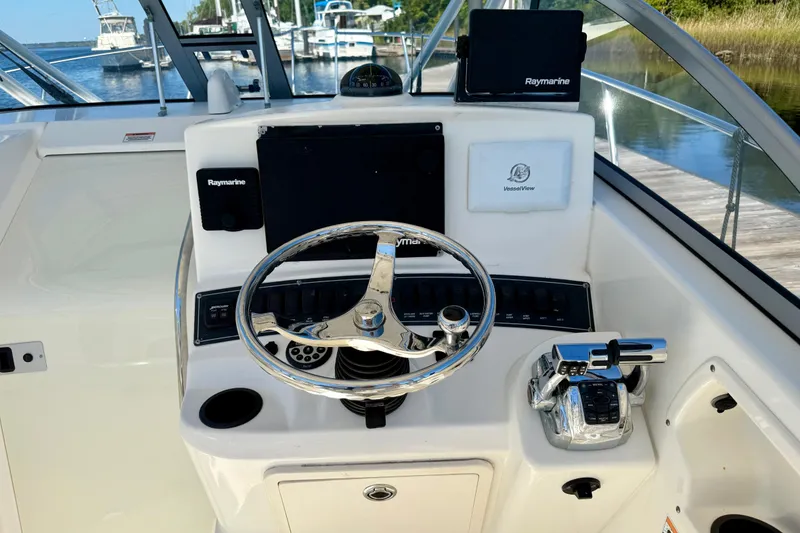 Slide: The Image of 2007 Boston Whaler 285 Conquest helm with Raymarine electronics and chrome steering wheel. - 17