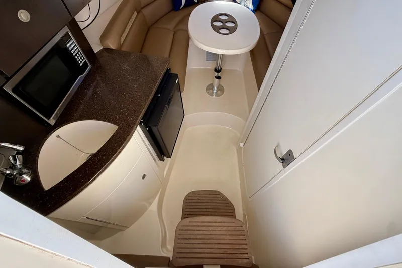 Slide: The Image of 2007 Boston Whaler 285 Conquest cabin interior with kitchenette and seating area. - 18