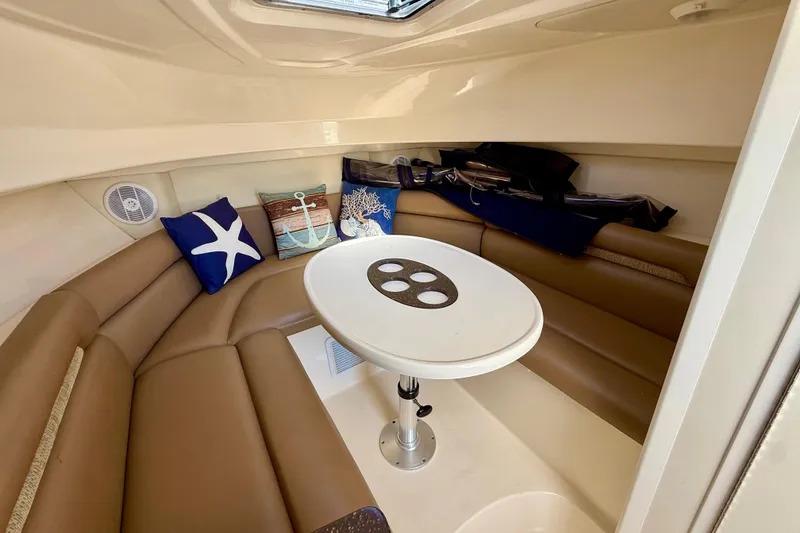 Slide: The Image of 2007 Boston Whaler 285 Conquest cabin interior with seating and nautical-themed cushions. - 20