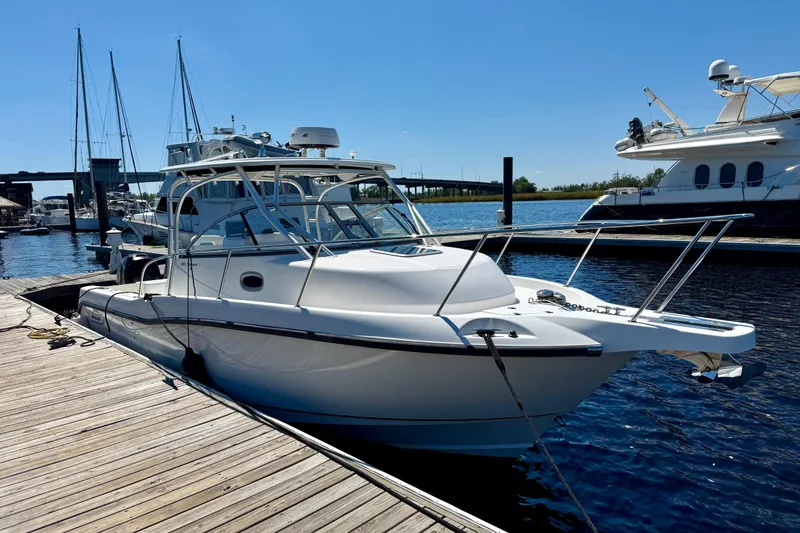 Slide: The Image of 2007 Boston Whaler 285 Conquest docked at marina under clear blue sky. - 7