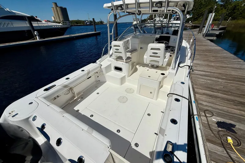 Slide: The Image of 2007 Boston Whaler 285 Conquest boat docked, showcasing spacious deck and seating area. - 9