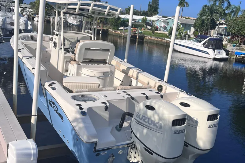 Slide: The Image of 2019 Sea Chaser 27 HFC boat with dual Suzuki engines docked in a marina. - 3