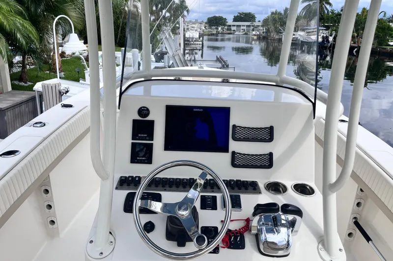Slide: The Image of 2019 Sea Chaser 27 HFC boat dashboard with steering wheel and navigation controls. - 4
