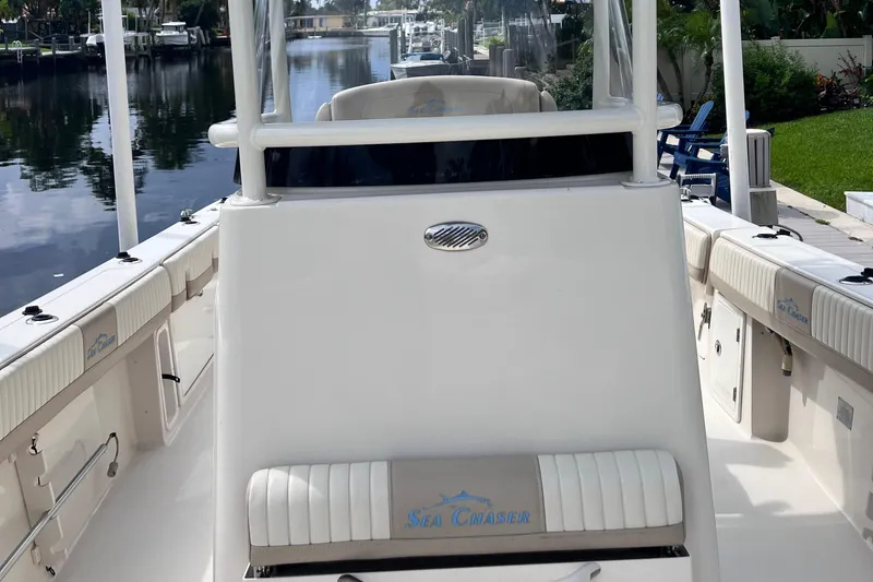 Slide: The Image of 2019 Sea Chaser 27 HFC boat interior, featuring seating and console, docked by a canal. - 8