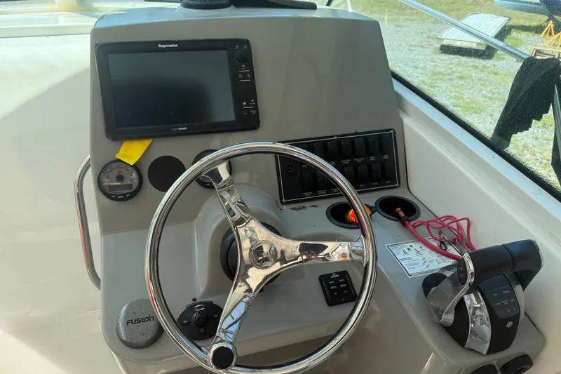 Slide: The Image of Helm of 2014 Boston Whaler 285 Conquest with steering wheel and navigation controls. - 10