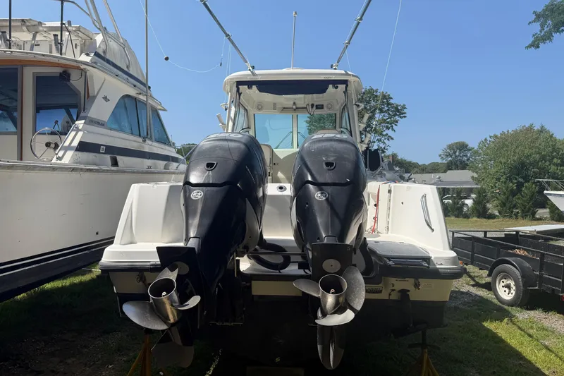 Slide: The Image of 2014 Boston Whaler 285 Conquest with dual outboard motors, docked outdoors. - 4