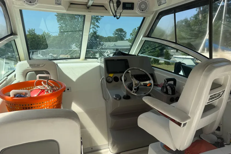 Slide: The Image of Interior of 2014 Boston Whaler 285 Conquest boat with steering wheel and basket. - 9