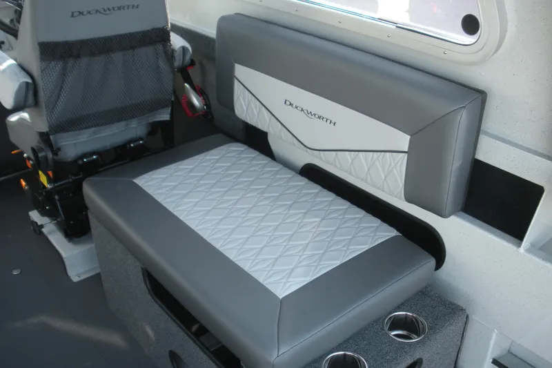 Slide: The Image of Interior seating of 2026 Duckworth 26 Pacific Pro boat, featuring gray upholstery and cup holders. - 11