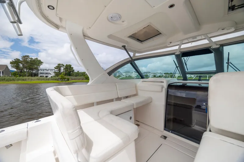 Slide: The Image of 2004 Tiara Yachts 3200 Open interior with white seating and scenic water view. - 12