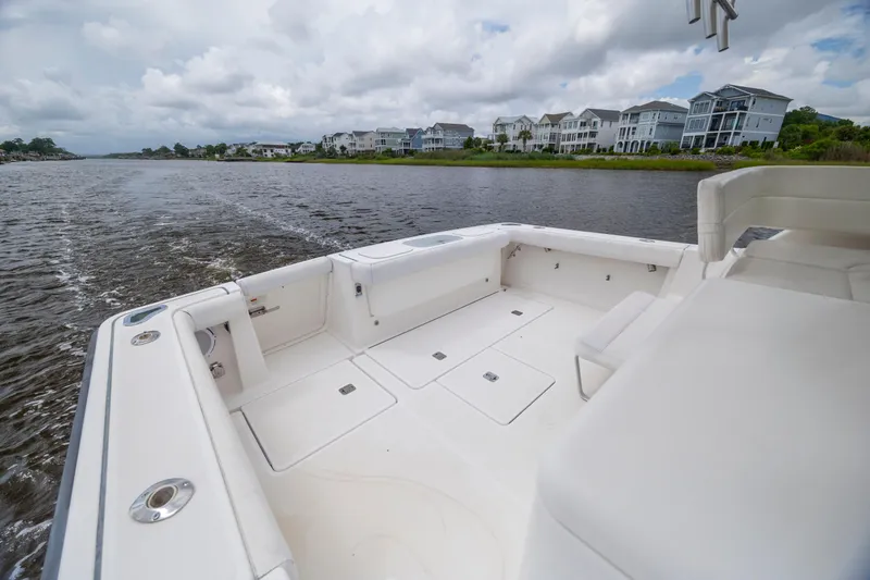 Slide: The Image of 2004 Tiara Yachts 3200 Open boat cruising on a river with waterfront homes in view. - 14
