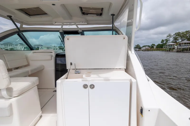 Slide: The Image of 2004 Tiara Yachts 3200 Open interior with seating and kitchenette, dockside view. - 19