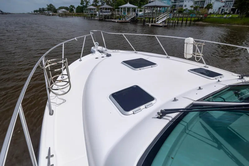 Slide: The Image of 2004 Tiara Yachts 3200 Open on calm water, showcasing sleek deck design and hatches. - 22