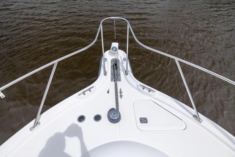 Slide: The Image of Bow of 2004 Tiara Yachts 3200 Open, featuring anchor and railing over water. - 23